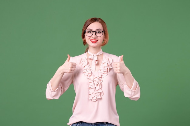 Front view female teacher in pink blouse on green