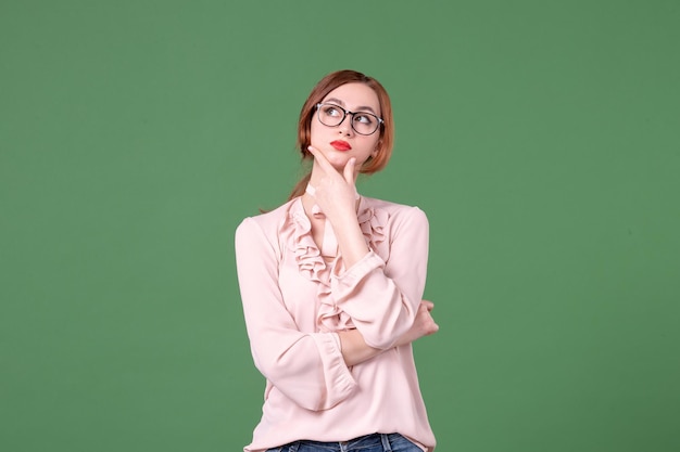 Front view female teacher in pink blouse on green