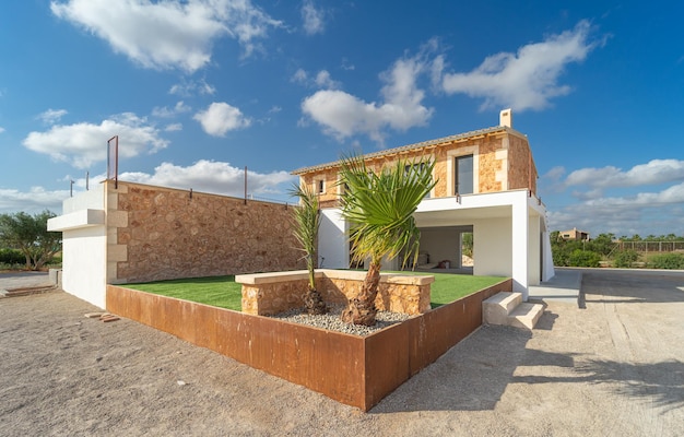 Front view of the garden with artificial grass and the facade of a country house in Majorca, Spain