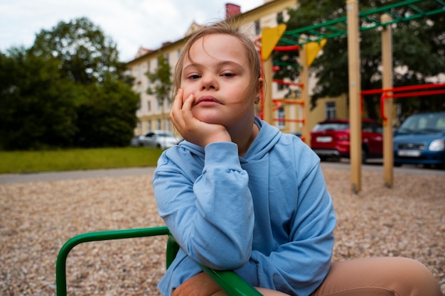 Front view girl with down syndrome outdoors