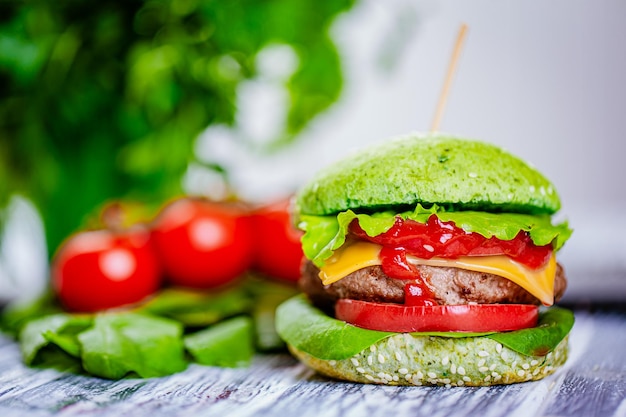 Front view of green burger with artificial meat fresh vegetables on wooden table Vegetarian food