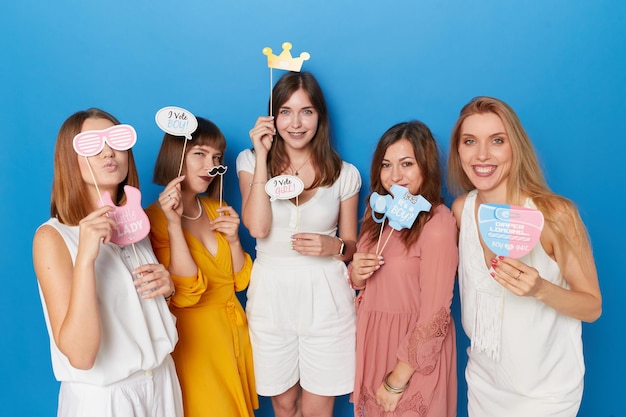 Front view of a group of joyful women to have gender reveals envent isolated blue background Copy space