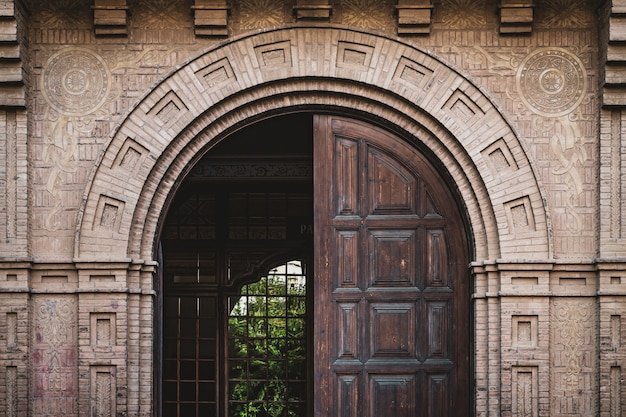 Front view of a half opened wooden door from an industrial building