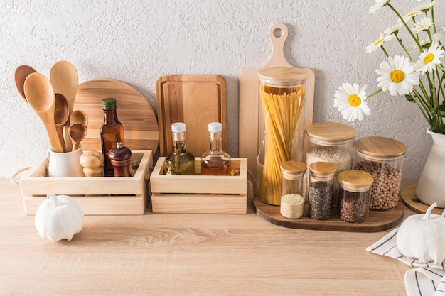 Front view of the kitchen wooden countertop with various kitchen utensils cans with various dry products storage concept eco kitchen interior