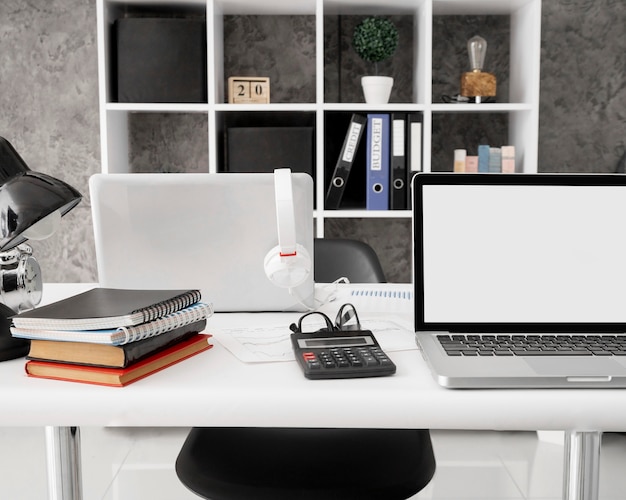 Photo front view of laptops with notebooks and calculator on office desk