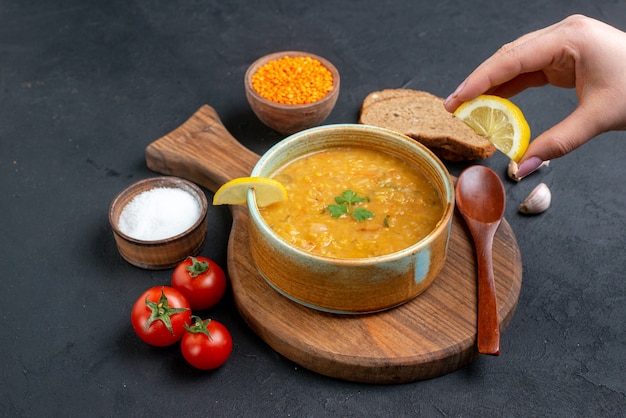 Front view lentil soup with salt tomatoes and dark bread loafs on dark floor food diner colourful meal dish bread horizontal