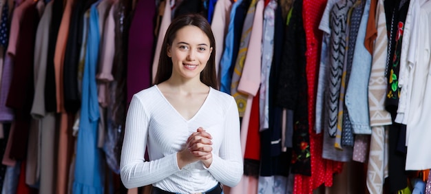 Front view look forward happy look holding hands crossed fingers young teen girl in clothing store