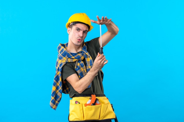 front view male builder in helmet holding screwdriver on blue background flat architecture house job building worker constructors