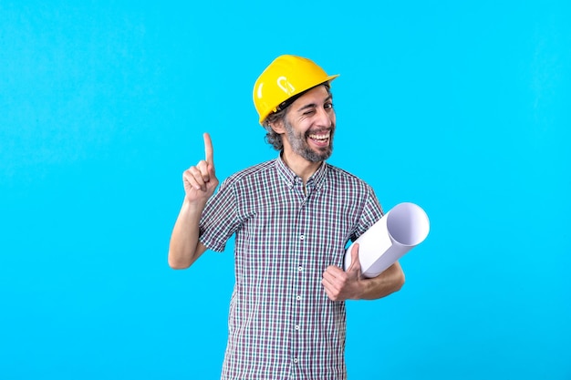 Front view male builder holding plan on blue