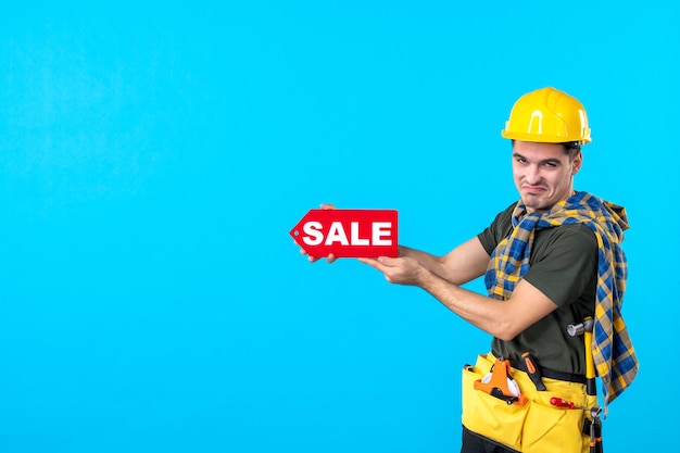 front view male builder holding red sale writing on the blue background flat architecture constructor building property color worker