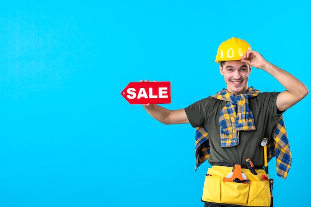 Photo front view male builder holding sale writing on blue background flat architecture constructor color worker buildings money property