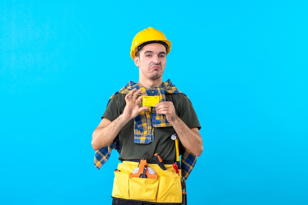 front view male builder in yellow helmet holding bank card on blue background money color flat architecture worker constructor