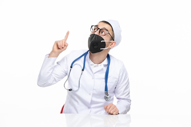 Front view male doctor in medical suit wearing special black mask