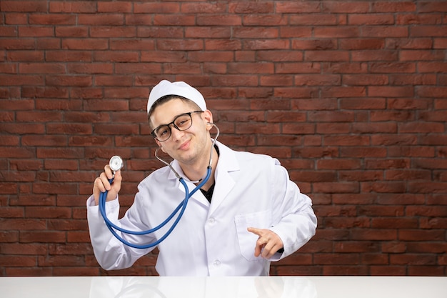 Front view male doctor in white medical suit with stethoscope