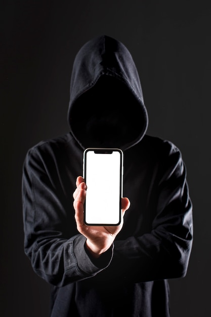 Front view of male hacker holding smartphone