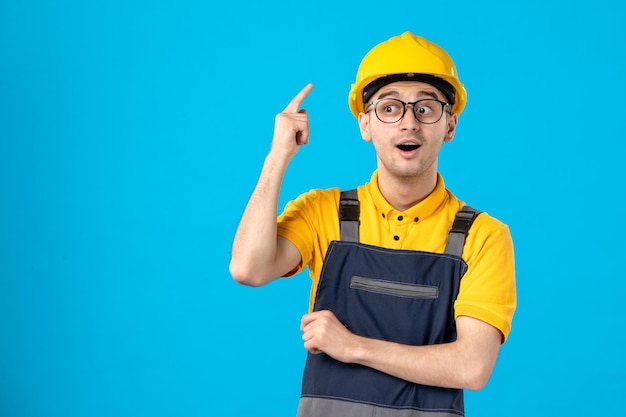 Front view of male worker in yellow uniform on a blue 