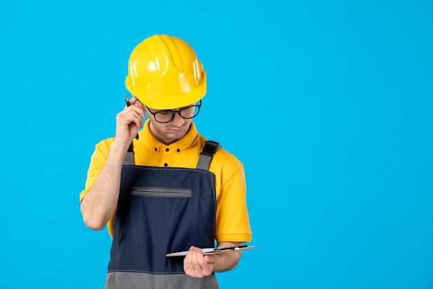 Front view of male worker in yellow uniform with file note on blue 