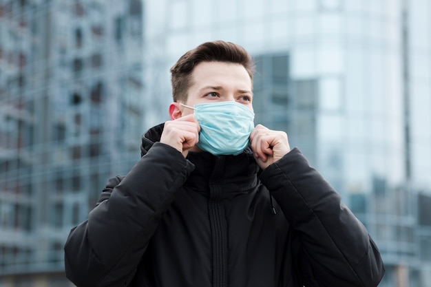 Front view of man in the city wearing medical mask