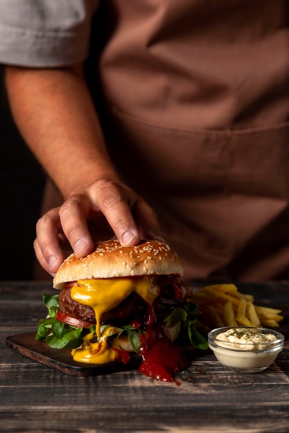 Front view man putting hand on burger