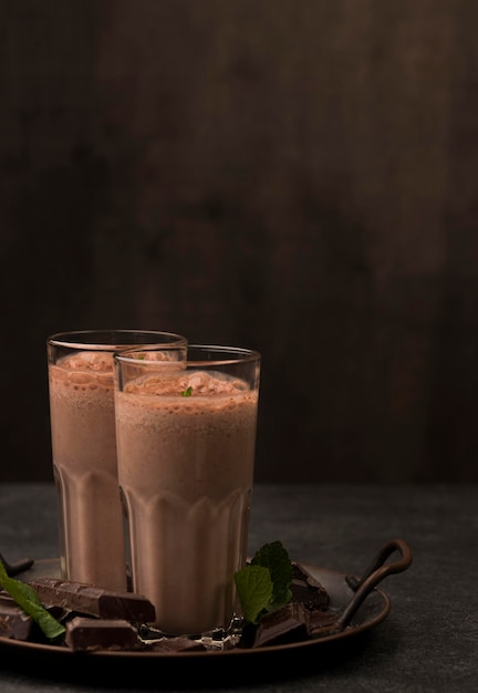 Front view of milkshake glasses with chocolate and copy space