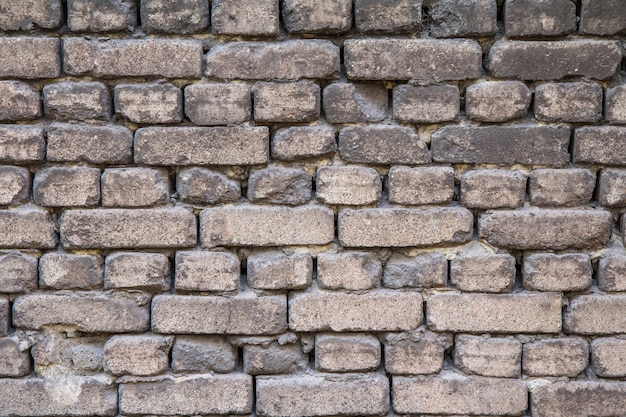 Front view of old brick wall in gray shade at natural light.