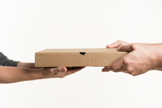 Front view of pair of hands holding pizza box