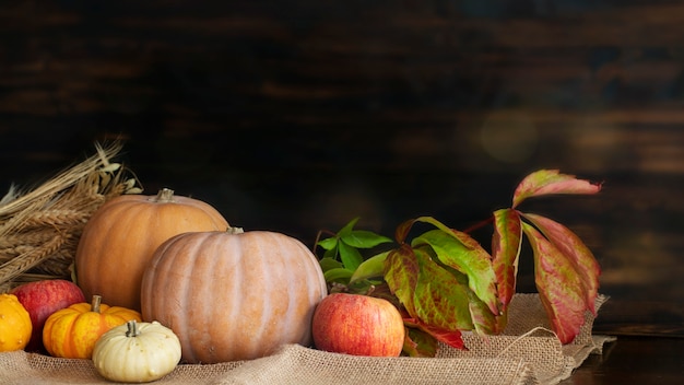 Front view of pumpkins on wooden table against wooden background