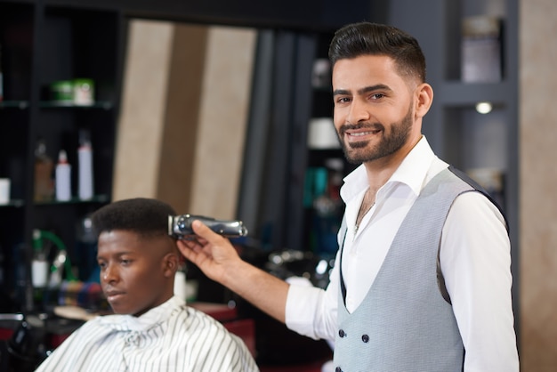 Front view of qualified barber posing in barber shop