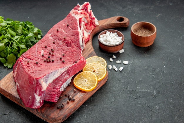 front view raw meat slice with lemon slices and seasonings on dark background cooking butcher dish food meat meal barbecue color dinner