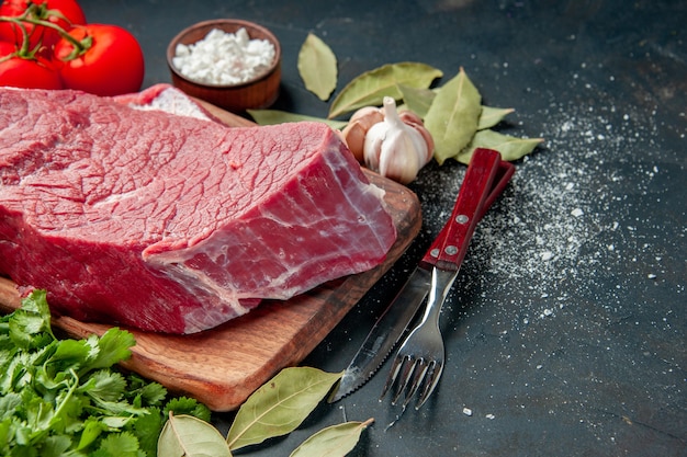 front view raw meat sliced with tomatoes and greens on a dark background color food meat barbecue cooking meal butcher