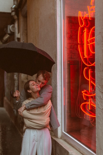 Front view romantic couple with umbrella