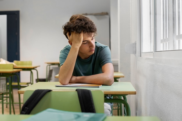 Front view sad teenager at school