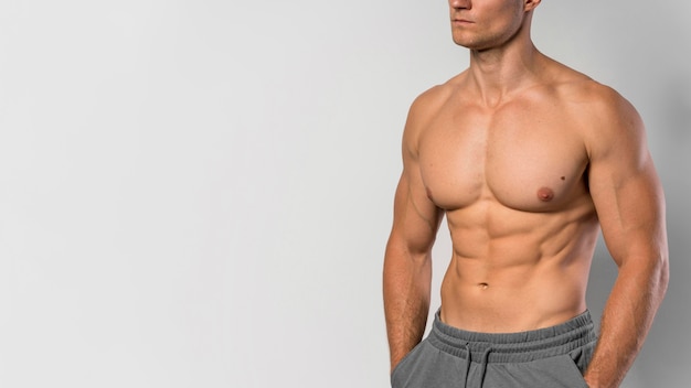 Front view of shirtless fit man posing with copy space