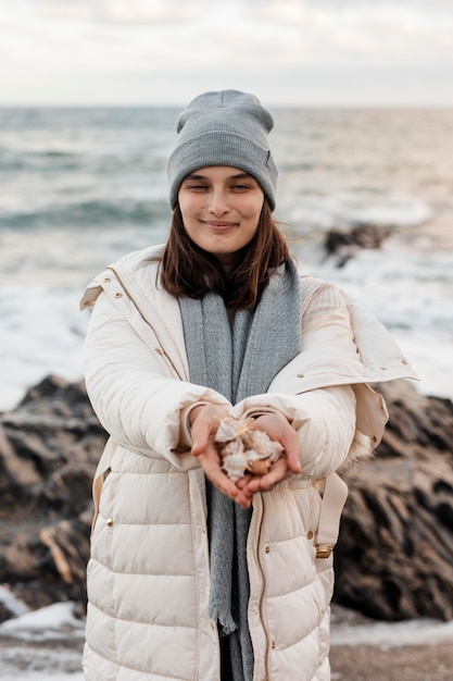 Front view of smiley woman holding seashells