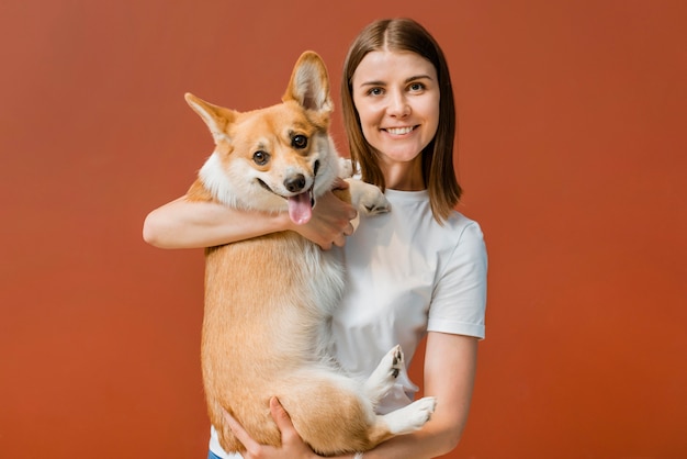 Front view of smiley woman posing with her cute dog