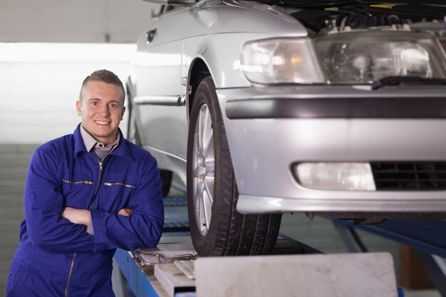 Front view of a smiling mechanic with arms crossed