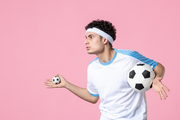 Front view soccer player in sport clothes with ball