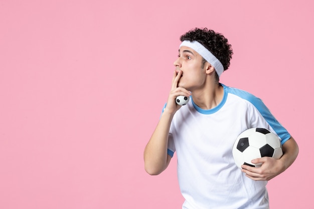 Front view soccer player in sport clothes with ball