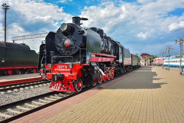 Front view of a steam train in station