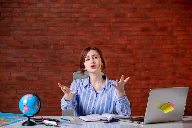 Front view stressed travel agent behind her working place map indoors manager operator agency world worker document service occupation