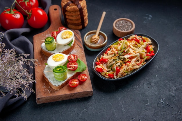 front view tasty egg sandwiches with tomatoes and pepper salad on cutting board dark background lunch toast snack burger sandwich food bread meal