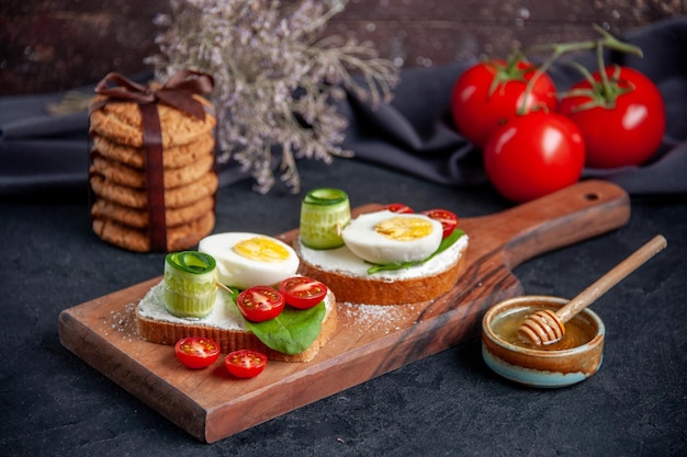 front view tasty sandwiches with tomatoes and eggs on cutting board dark background toast meal snack sandwich lunch food bread