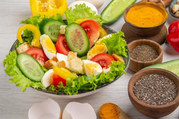 Front view tasty vegetable salad with seasonings on a white background meal food breakfast ripe color