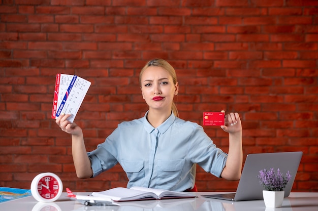 front view of travel agent holding tickets and red credit card assistant global occupation agency money job working manager map