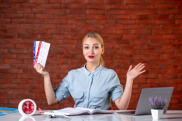 front view of travel agent sitting behind her working place with plane tickets global manager indoors agency service map occupation assistant tourism