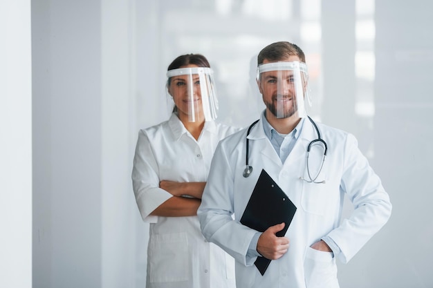 Front view Two doctors in white coats is in the clinic working together