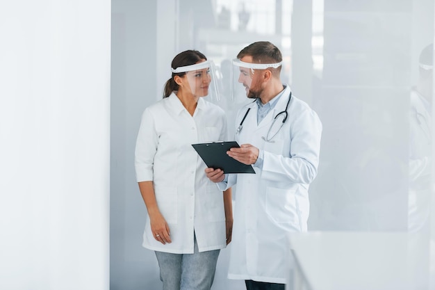 Front view Two doctors in white coats is in the clinic working together