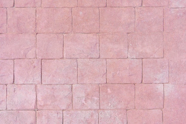 Front view of a wall of irregular shape tiles or slabs Reddish textured background