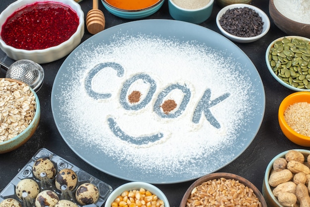 front view white flour with eggs nuts seeds raisins and jelly on dark background cake breakfast food pie bake color cook heart