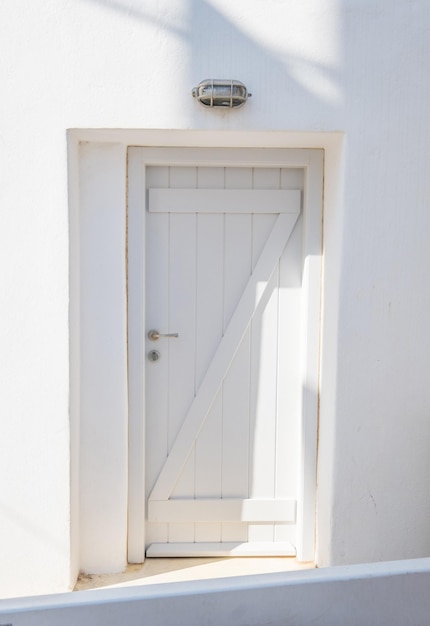 Front view of white wooden door in a white wall